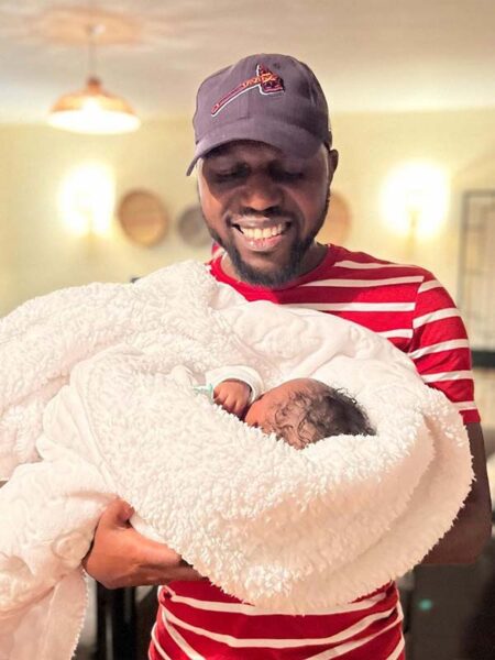 Larry Madowo holding a baby boy [son]
